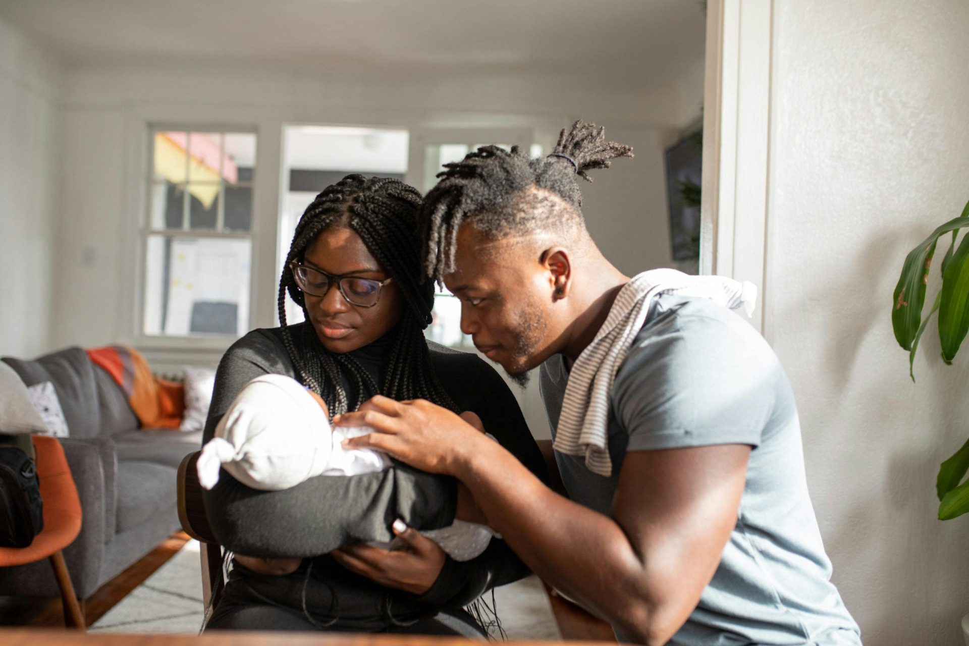Loving parents embracing their newborn baby at home, capturing a tender family bond.